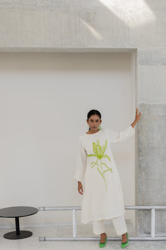 white cotton kurti,white a-line kurti,embroidered white kurti,cotton flex kurta set,green embroidery kurti,stylish white kurta,white kurti with pant,minimalist ethnic wear,modern white kurti,designer cotton kurti,white kurta for women,a-line kurta design,elegant white kurti,white kurti for summer,office wear kurta set,casual white kurti look,indian cotton kurta,pocket pants set,white kurta outfit,hand embroidery kurti,white ethnic dress,women's kurta set,floral embroidered kurti,white kurti with green work,