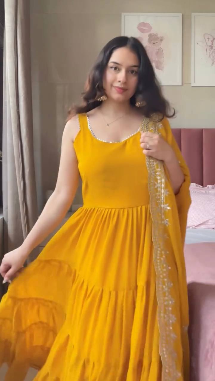Woman in a yellow dress holding a dupatta